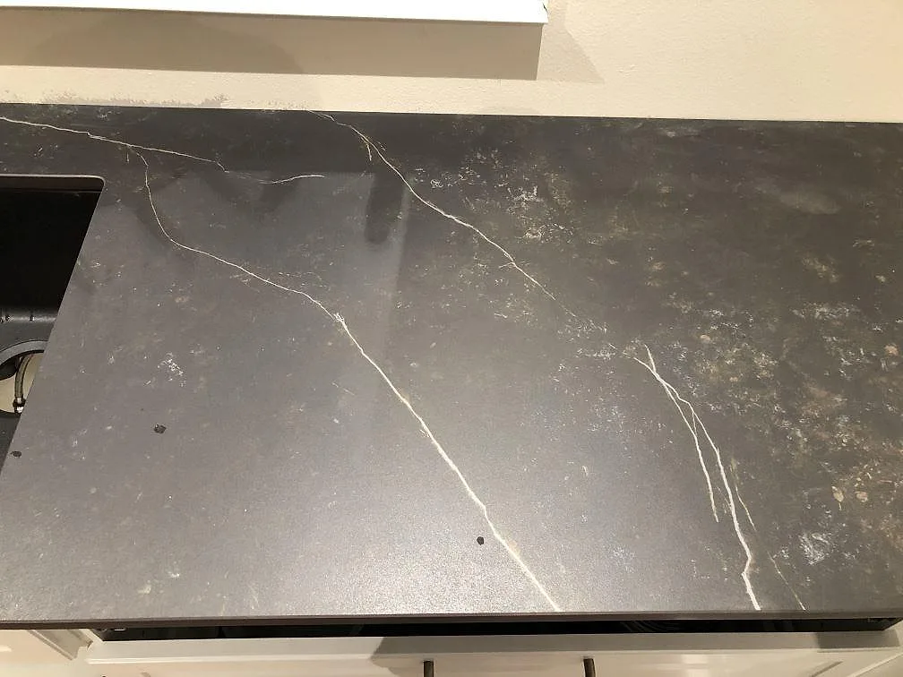 Detalj av väggbänk i Dekton Kelya, matt, med diskho vid kanten och ådrad yta i Kärna.