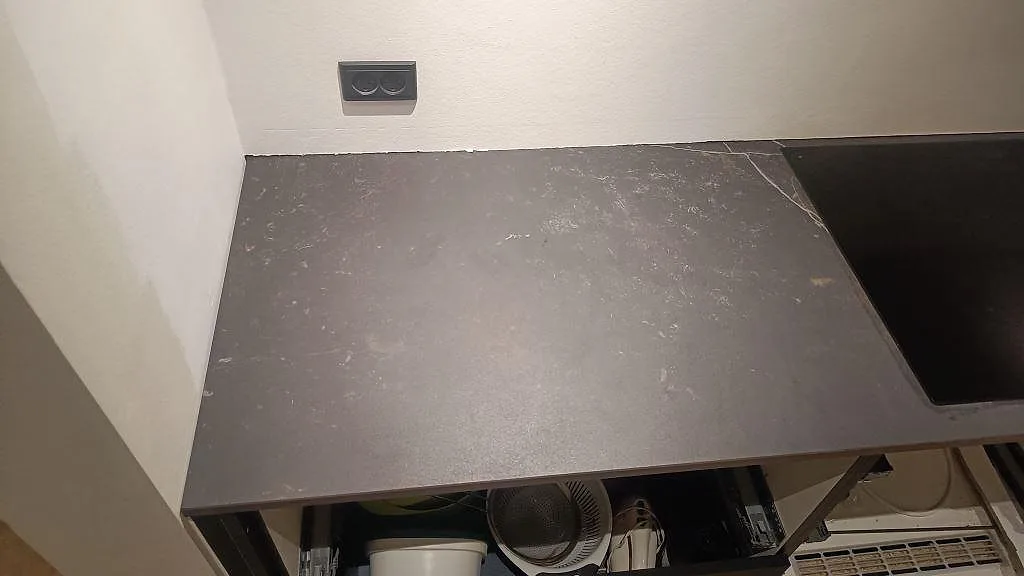 Vänster del av den matta Dekton Kelya bänkskivan med hällkant och öppen stomme i Kolding.