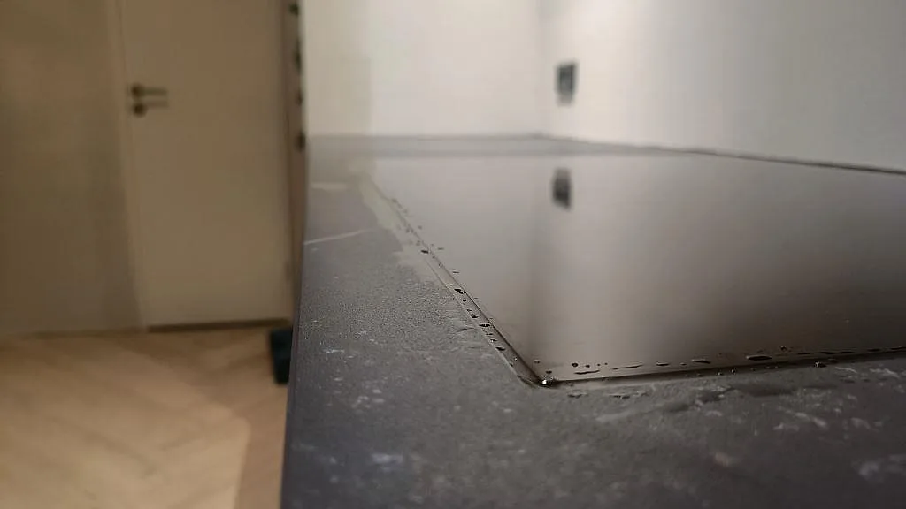 Låg detaljbild av hällens kant i en matt Dekton Kelya köksbänkskiva i Kolding.