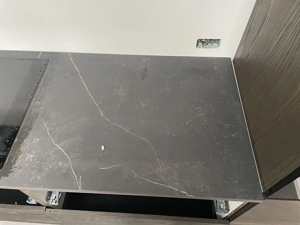 Ovanvy av matt mörkgrå Dekton Kelya bänkskiva med markerad vit ådring i ett kök i Kr.Hyllinge.