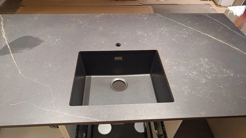 Närbild av matt Dekton Kelya som köksbänkskiva med underlimmad svart diskho och blandarhål i Kungsbacka.