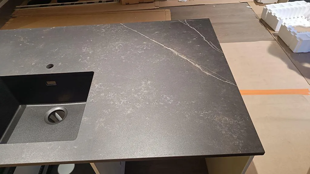 Topvy av matt Dekton Kelya med underlimmad svart diskho och ådrad yta på köksbänkskiva i Kungsbacka.