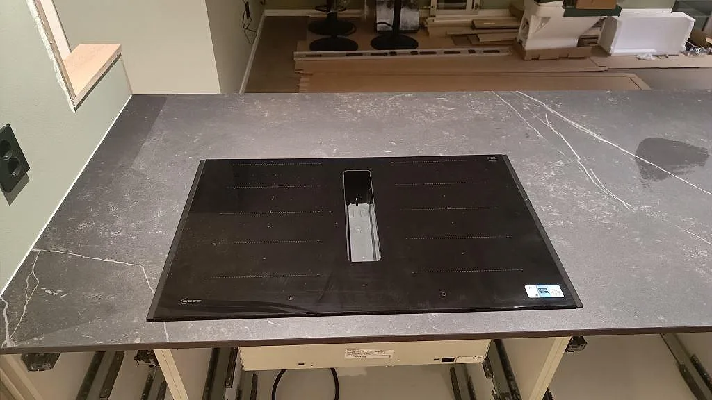 Matt köksbänkskiva i Dekton Kelya med infälld häll och tydlig ljus ådring i ett kök i Kungsbacka.