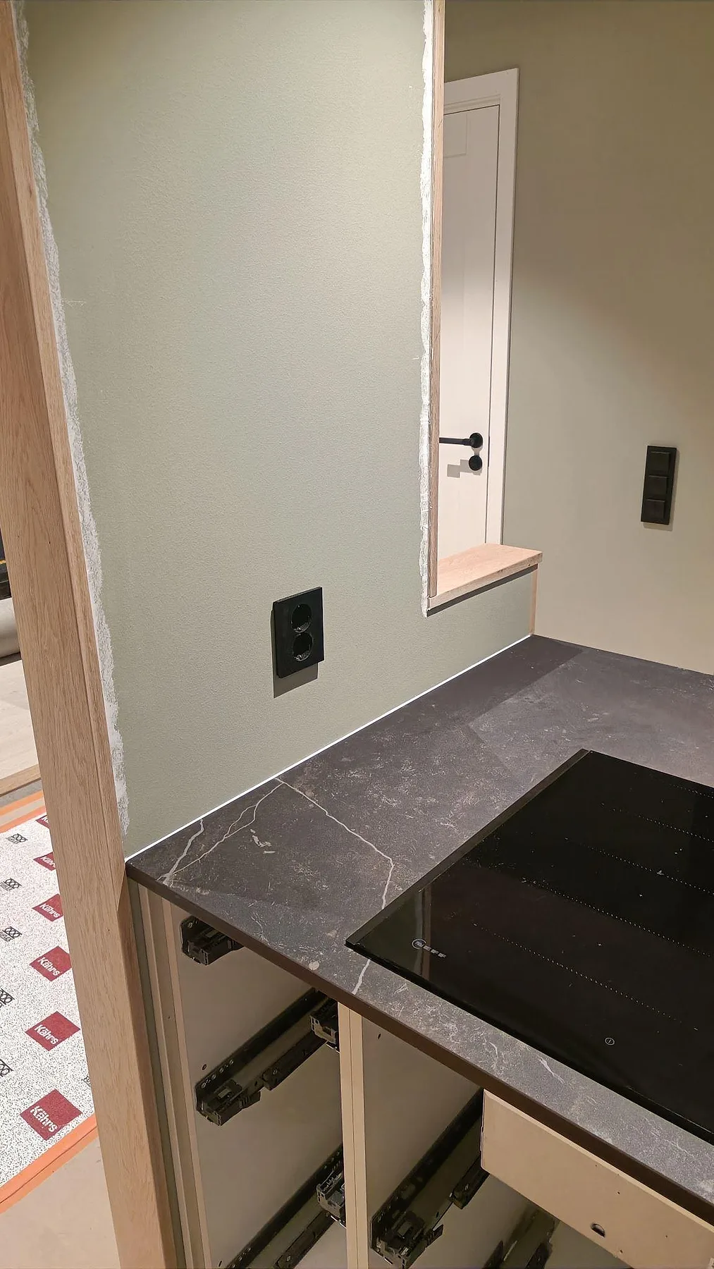Hällhörn med matt Dekton Kelya, mörk ådring och bänkskiva vid fönster i ett kök i Kungsbacka.