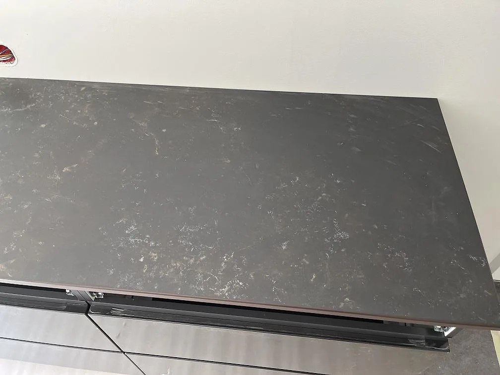 Köksö i Dekton Kelya, grå matt keramikskiva med diskret ådring, sedd ovanifrån i ett kök under installation i Löddeköpinge.