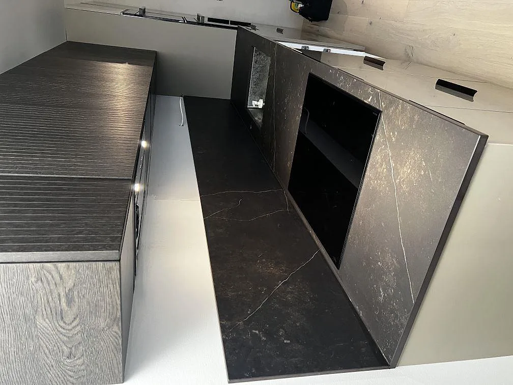Köksbänkskiva i mörk Dekton Kelya, matt, med matchande stänkskydd och häll i ett kök i Malmö.