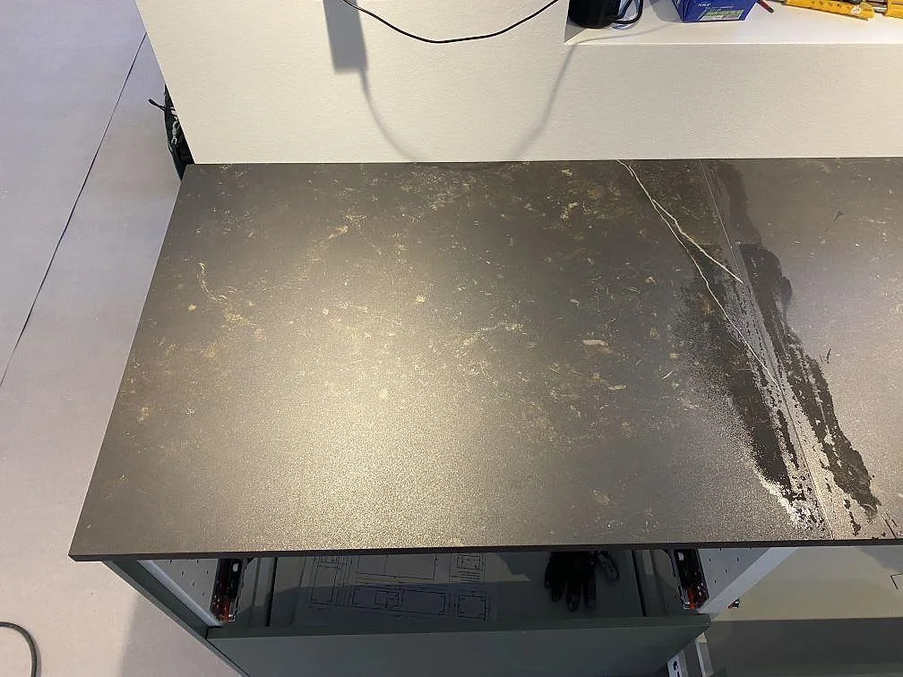 Detalj av matt Dekton Kelya bänkskiva med mörk yta, ljus ådra och monterad väggsträcka i Ringsted.