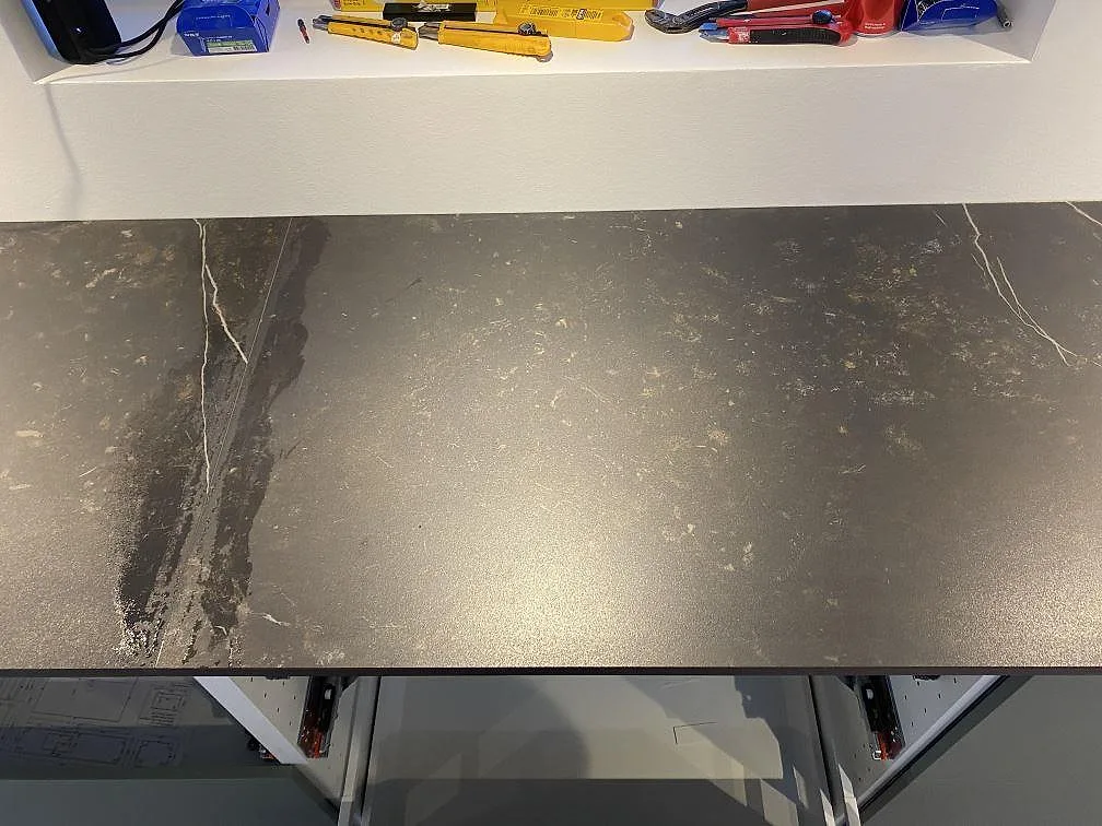 Rak bänkskiva i matt Dekton Kelya med gråsvart keramikyta och marmorerad ådring i kök i Ringsted.
