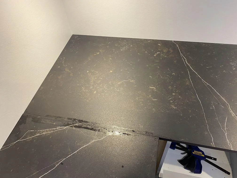 Hörnparti av köksbänkskiva i matt Dekton Kelya med mörk keramikyta och ljusa ådror i Ringsted.