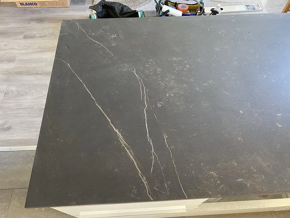 Närbild av matt Dekton Kelya på köksön med mörk keramikyta och ljusa ådringar i Skanör.