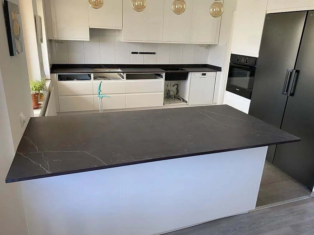 Matt köksbänkskiva i Dekton Kelya med stor köksö och väggbänk i ett kök i Skanör.