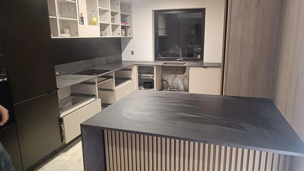 Matt köksbänkskiva i Dekton Kelya med stor köksö, fallande sidor och perimeterbänkar i ett kök i Staffanstorp.