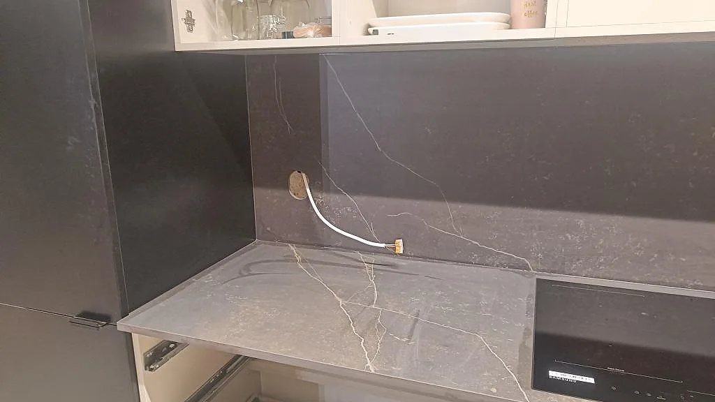 Perimeterbänk i matt Dekton Kelya med mörkt stänkskydd och synlig ådring i kök i Staffanstorp.