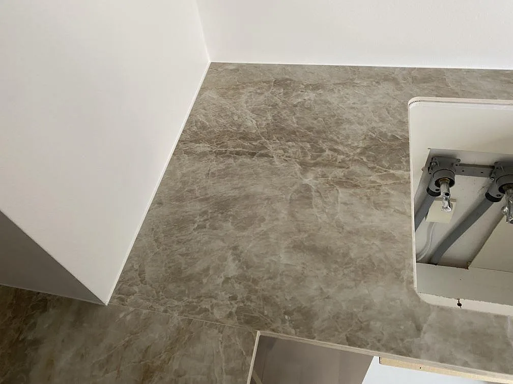 Topvy av gråmarmorerad Dekton Kelya bänkskiva i matt finish runt diskhoöppning under montering i Viby Sjælland.
