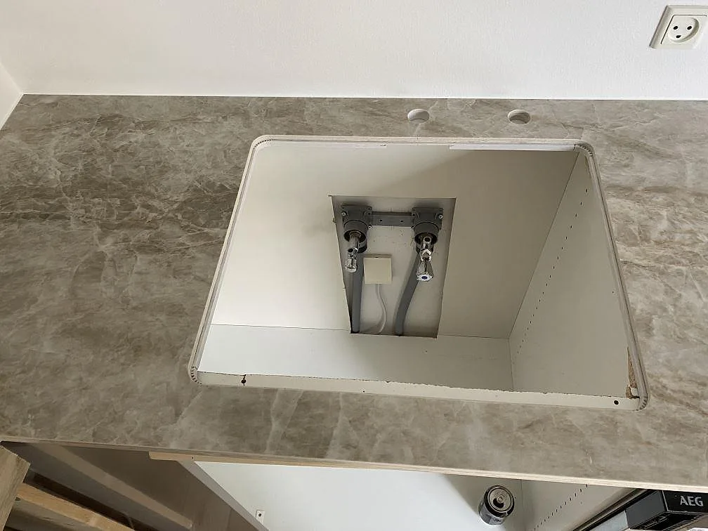 Diskhoöppning och kranhål i en matt Dekton Kelya köksbänkskiva med grå keramikyta i Viby Sjælland.