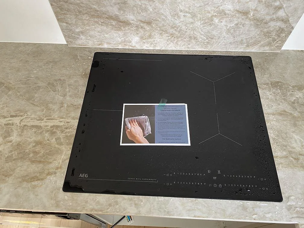 Svart häll monterad i en matt Dekton Kelya köksbänkskiva med matchande stänkskydd i Viby Sjælland.