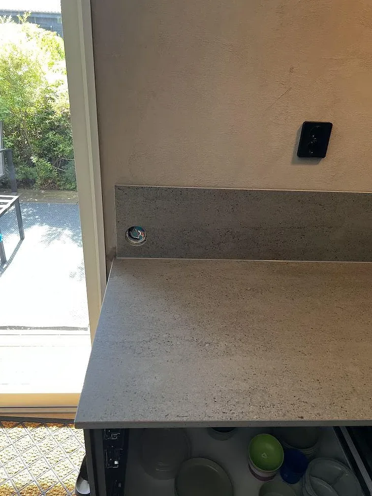 Detalj av matt Dekton Keon i grå keramik med 8 mm del och bänkskiva vid fönster i Falkenberg.