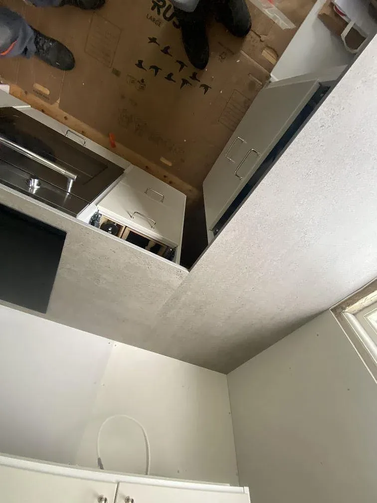 Köksbänkskiva i grå Dekton Keon kring induktionshäll och köksstommar i ett kök i Göteborg, matt yta under montering.