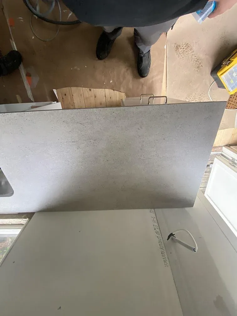 Köksbänkskiva i grå Dekton Keon med slät kant i ett kök i Göteborg, matt betongliknande yta under montering.