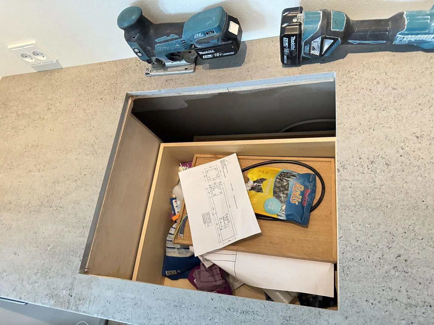 Detalj av rektangulärt urtag i köksbänkskiva av matt Dekton Keon, med verktyg på stenen under montering i Hørsholm.