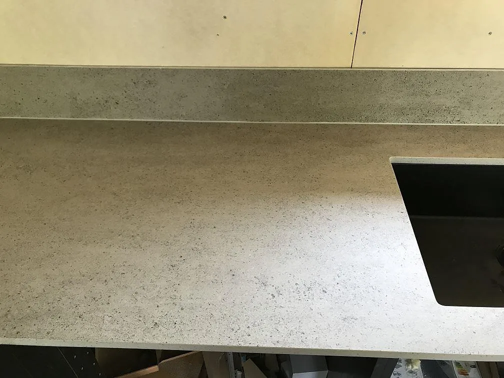 Bänkskiva i matt Dekton Keon med diskhoursnitt och stänkskydd i ett kök i Höviksnäs.