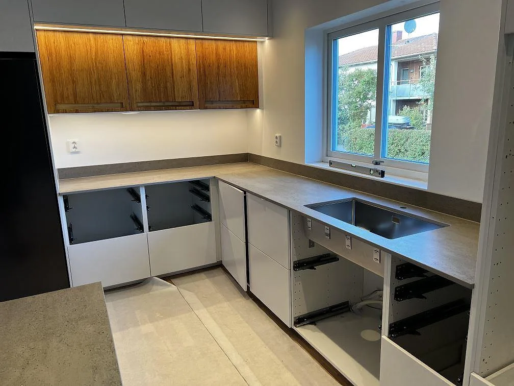 Köksbänkskiva i matt Dekton Keon keramik med underlimmad rostfri diskho, träklädda överskåp och stänkskydd i Kalmar.