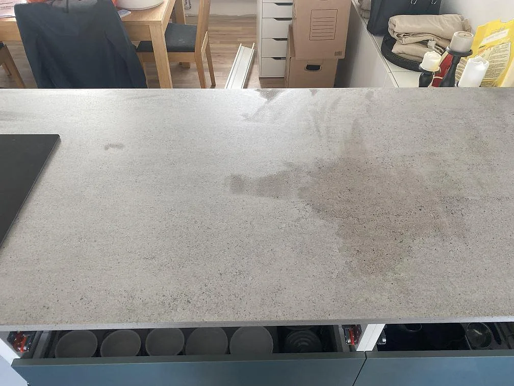 Halvö i grå Dekton Keon köksbänkskiva med öppna stommar under montering i ett kök i Klagstorp.
