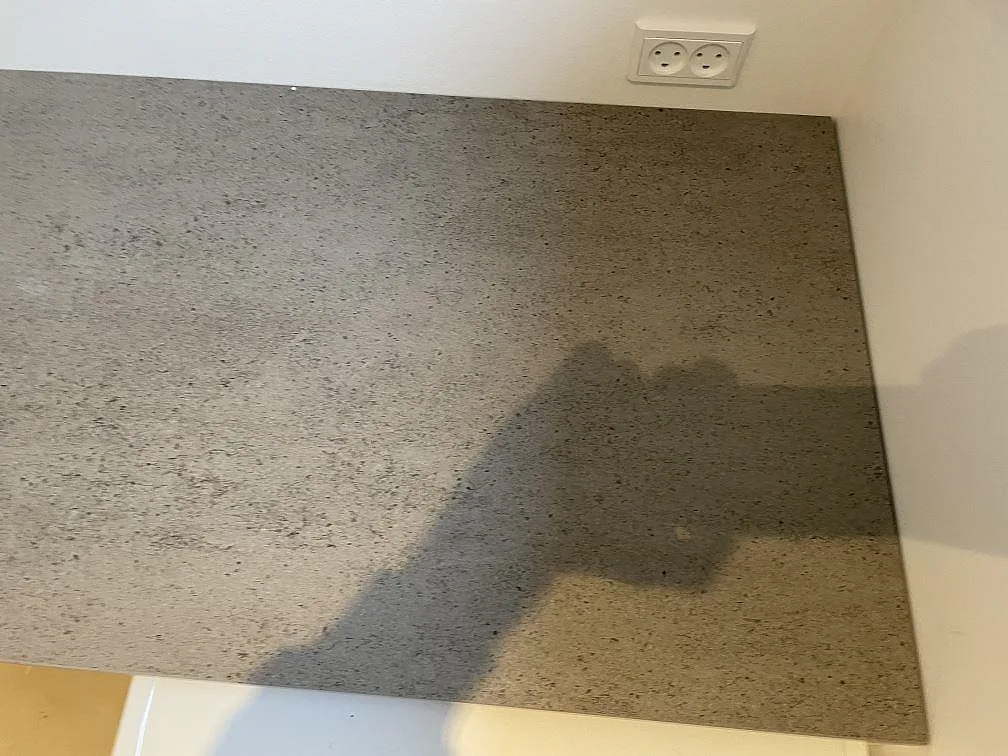 Närbild på matt grå Dekton Keon bänkskiva i keramik mot vägg i ett kök i Kr. Hyllinge.