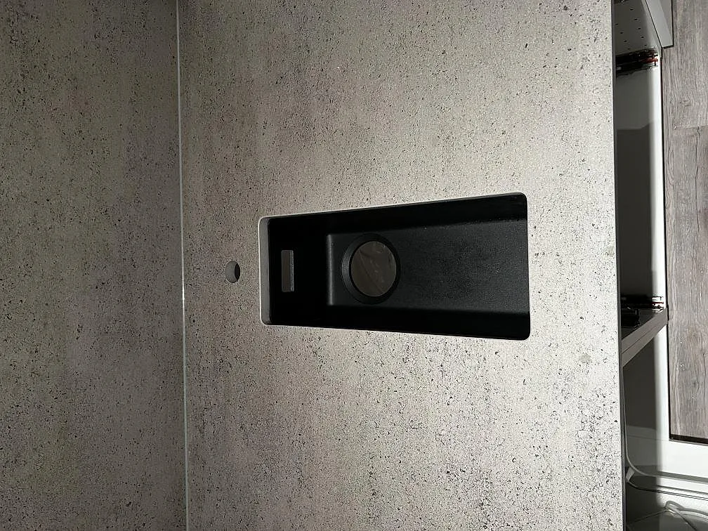 Mindre svart underlimmad diskho infälld i matt grå Dekton Keon köksbänkskiva i Kungsbacka.