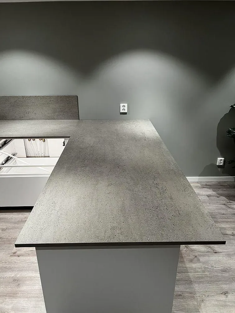 Köksö i matt grå Dekton Keon med cementlik yta i ett kök i Kungsbacka, eternivå i dagsljus.
