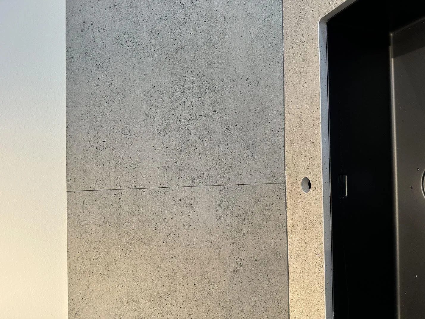 Ytdetalj vid diskho och stänkskydd i matt Dekton Keon på köksbänkskiva i Malmö.