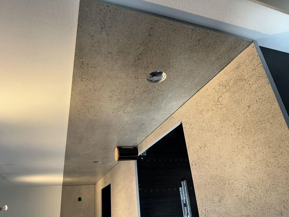 Lång vy över köksbänkskiva och stänkskydd i matt Dekton Keon under montering i Malmö.
