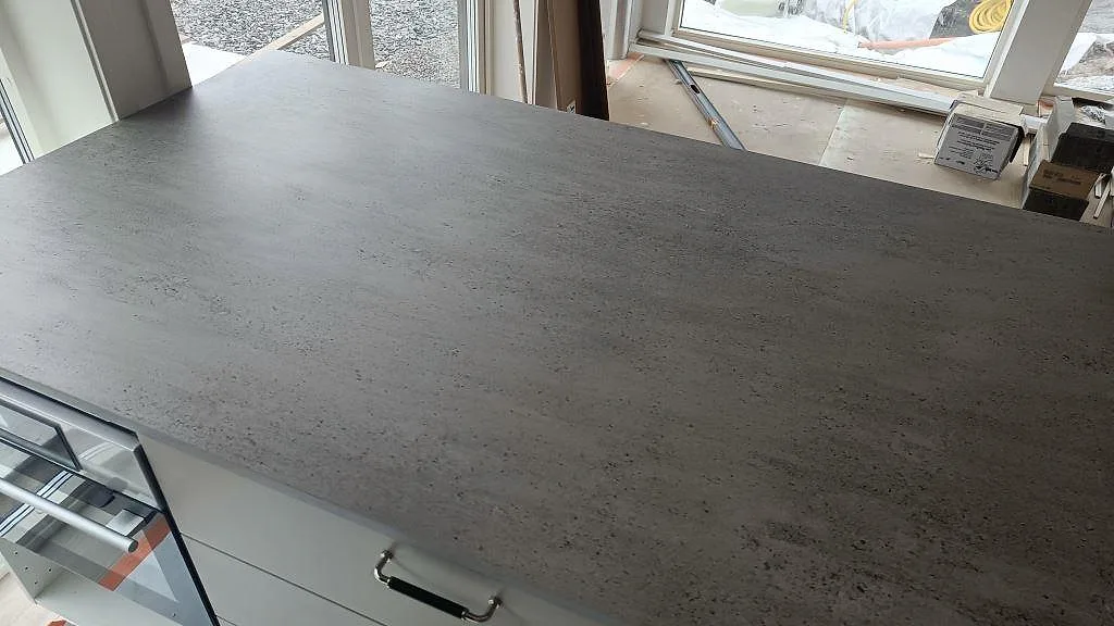Installerad köksbänkskiva i Dekton Keon, matt keramik, sedd över köksön i Marstrand.