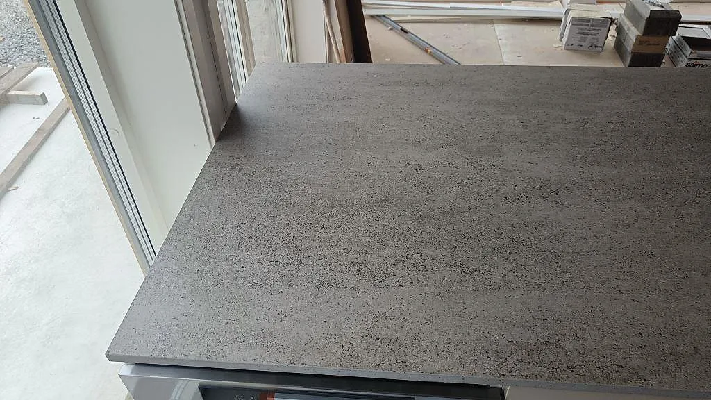 Detalj av kant och yta på matt Dekton Keon som köksbänkskiva vid stora fönster i Marstrand.