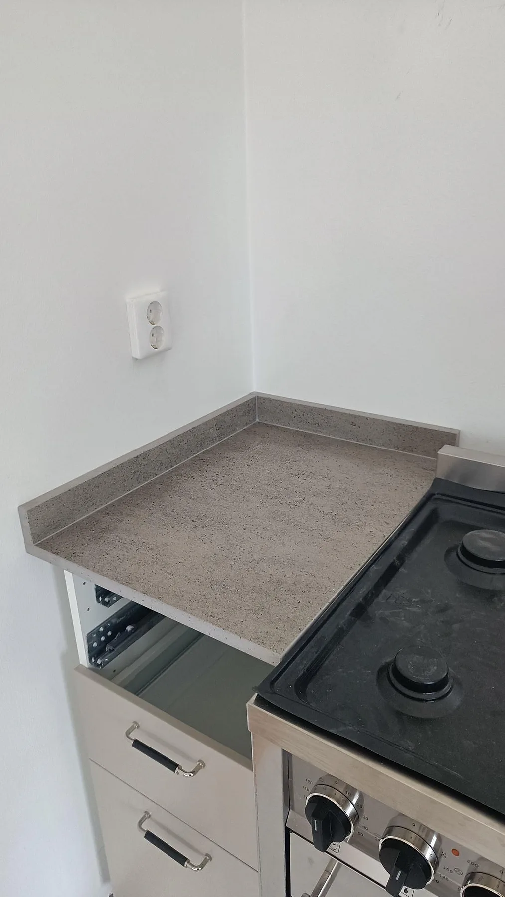 Sidobänk i matt Dekton Keon med uppvikt stänkkant vid spis i ett kök i Marstrand.