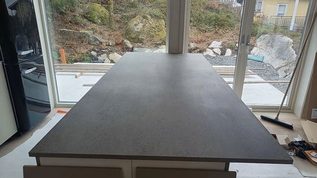 Köksbänkskiva i grå Dekton Keon, matt keramik, som köksö under montering i Marstrand.
