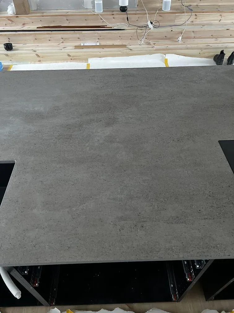 Ovanifrån av grå Dekton Keon köksbänkskiva i matt yta med urtag för häll och underlimmad diskho i ett kök i Stora Höga.