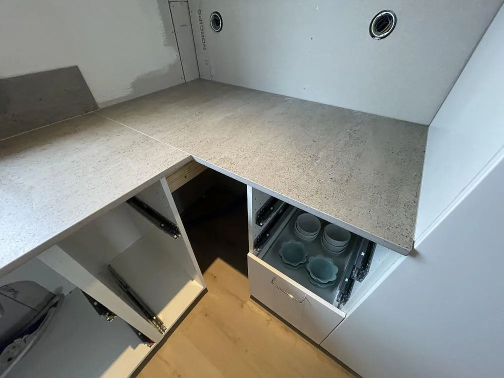 Närbild på hörnskarven i den matta Dekton Keon-bänkskivan mot vägg i ett kök i Surahammar.