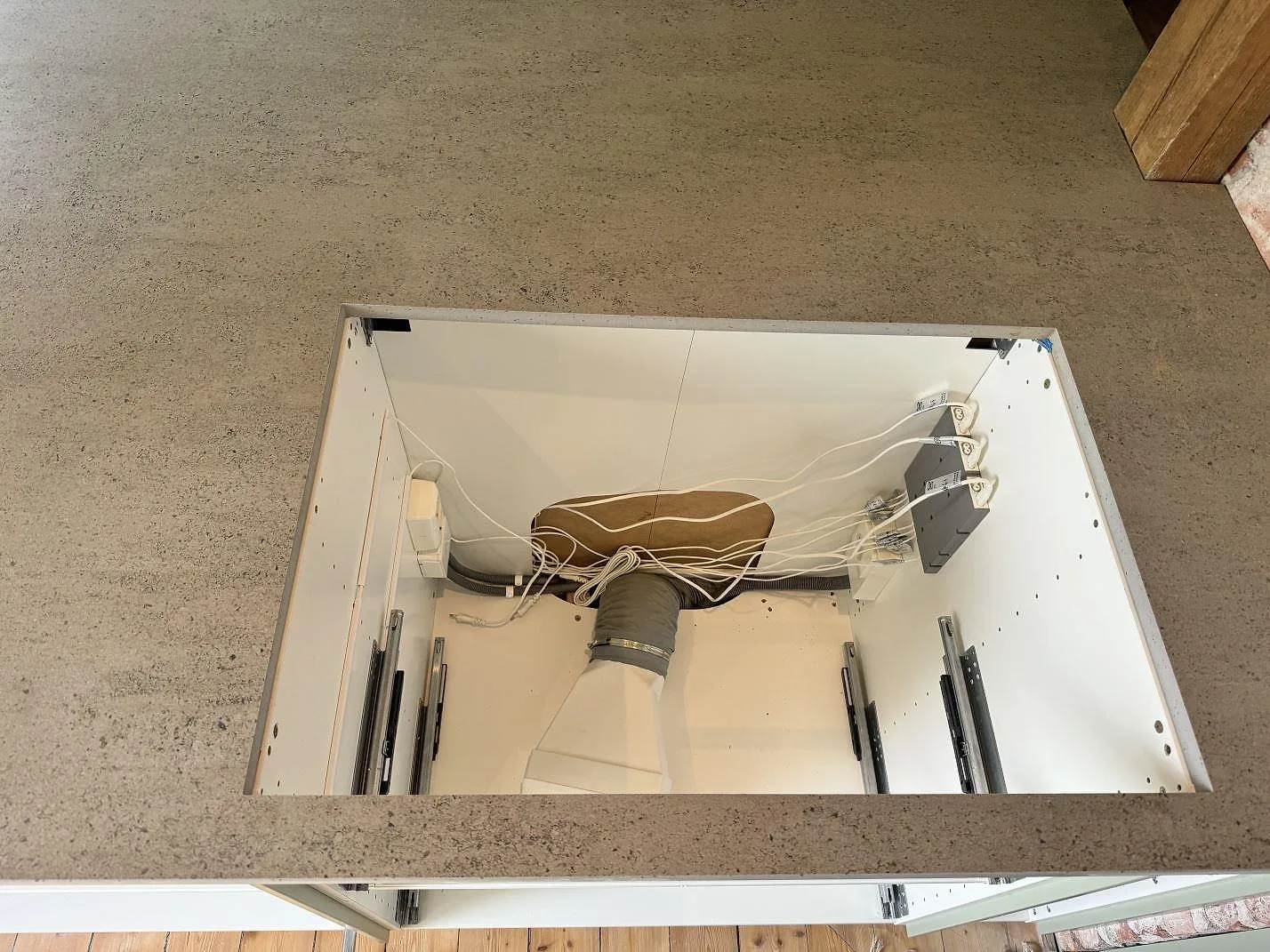 Närbild på matt Dekton Keon med stort urtag i köksbänkskivan under montering i Trollhättan.