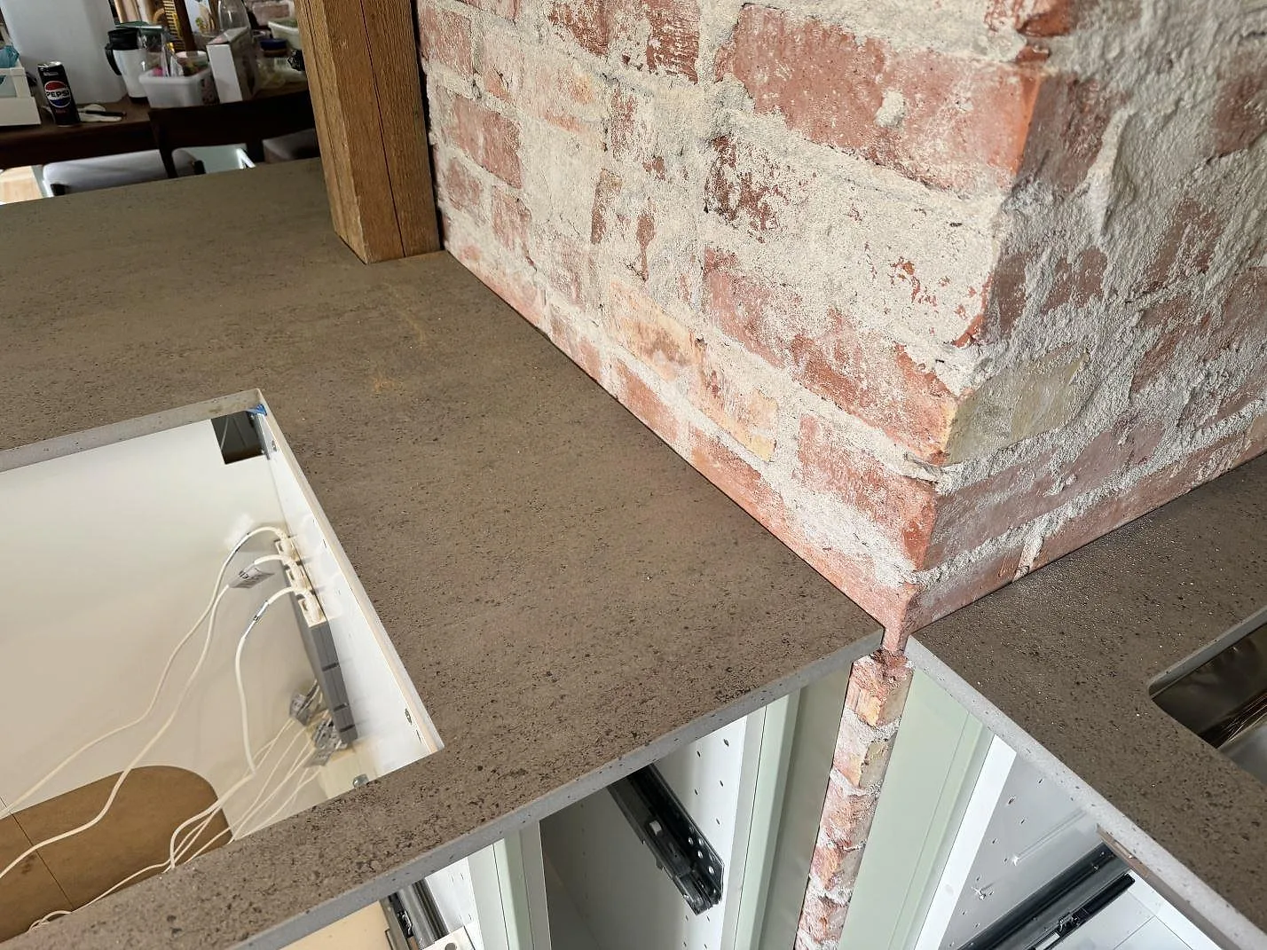 Matt Dekton Keon som arbetsyta runt murstock och öppna köksstommar i ett kök i Trollhättan.