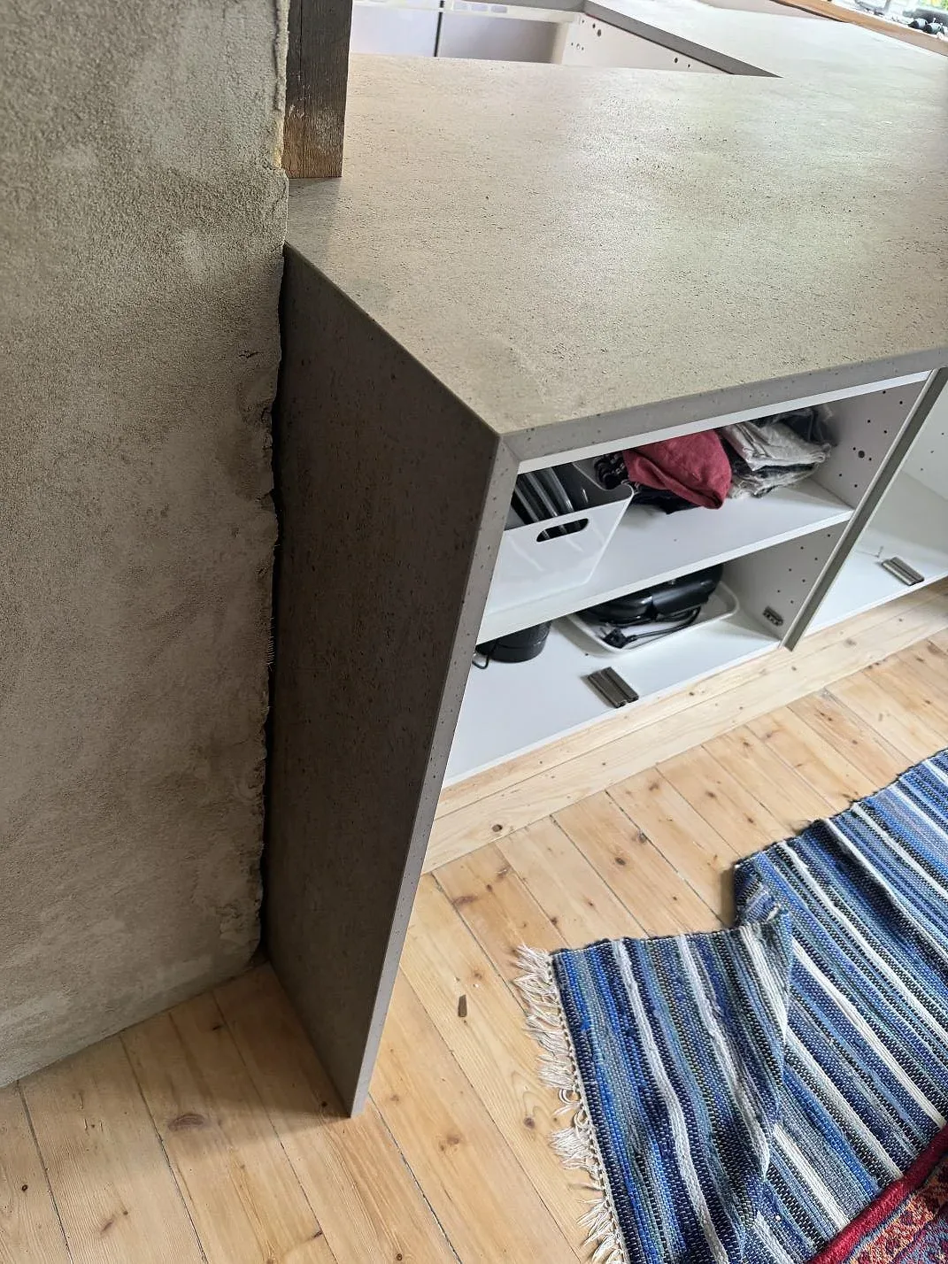 Köksö med neddragen sida i matt Dekton Keon, grå keramik, fotograferad under montering i Trollhättan.