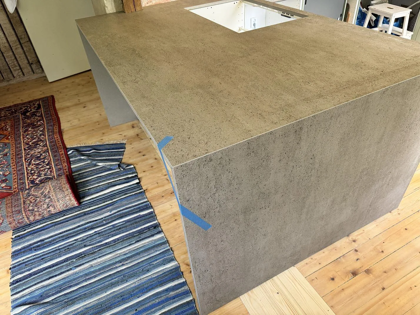 Matt köksbänkskiva i Dekton Keon med neddragen sida på en köksö under montering i Trollhättan.
