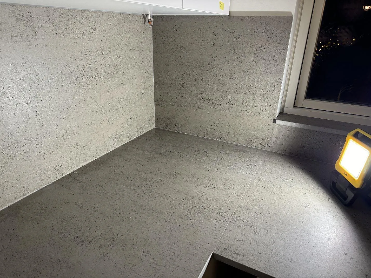 Köksbänkskiva i Dekton Keon, matt keramik, med arbetsbelysning och fönsterparti i Tygelsjö.