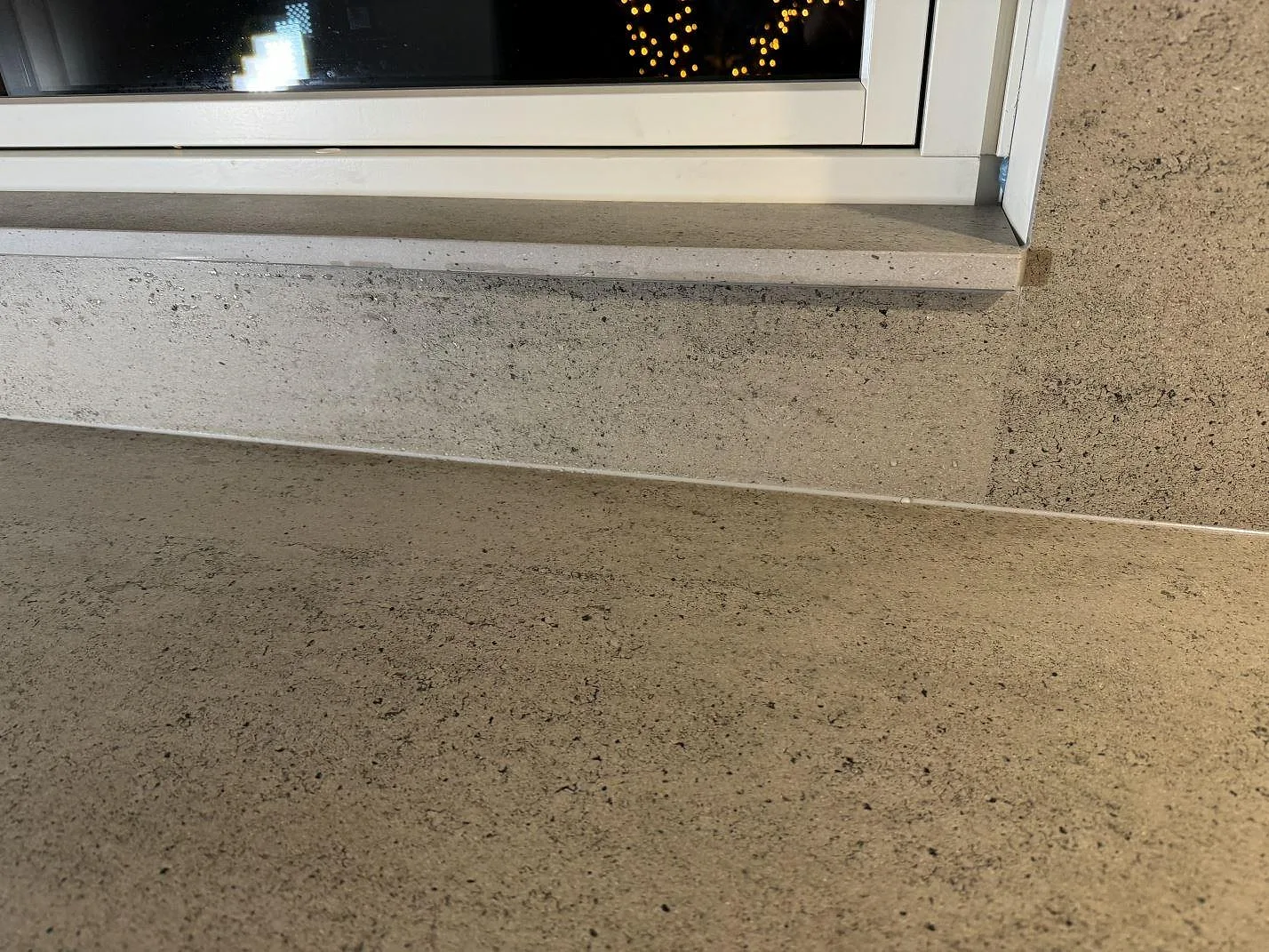 Detalj av fönsterbänk i matt Dekton Keon ovanför bänkskivan i köket i Tygelsjö.