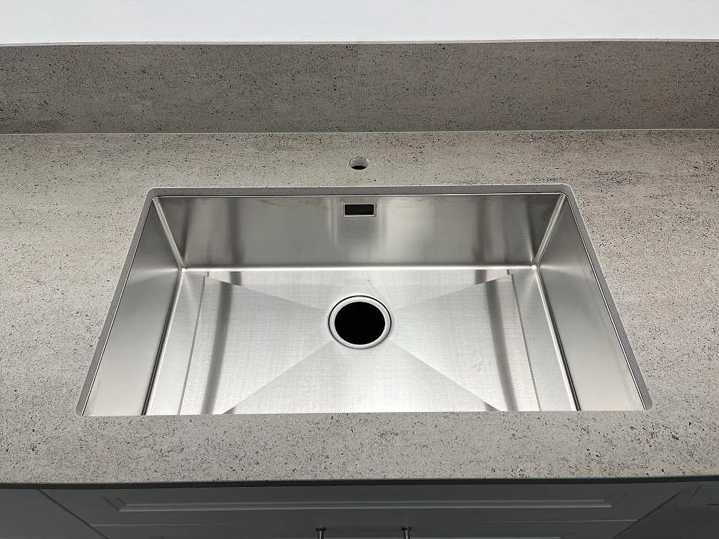 Underlimmad rostfri diskho i matt Dekton Keon, keramik, med blandarhål och låg stänkkant i Västerås.