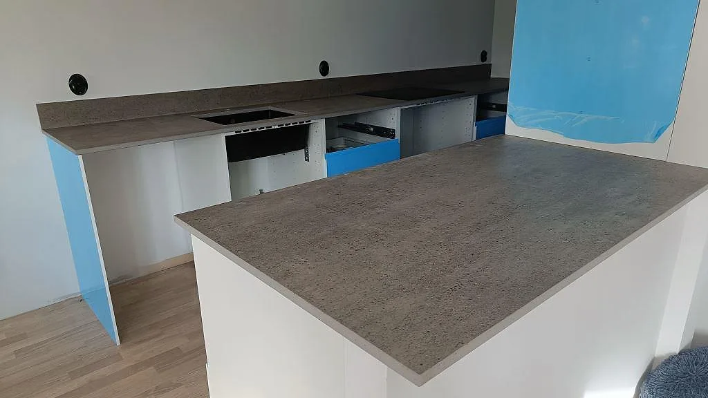Köksbänkskiva och köksö i grå Dekton Keon, matt keramik, monterade i ett kök i Veberöd.