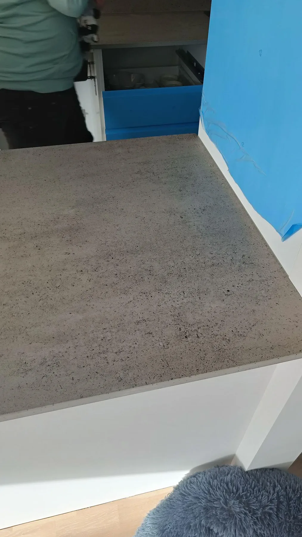 Närbild på köksö i grå Dekton Keon, matt keramik, med vit köksstomme i Veberöd.