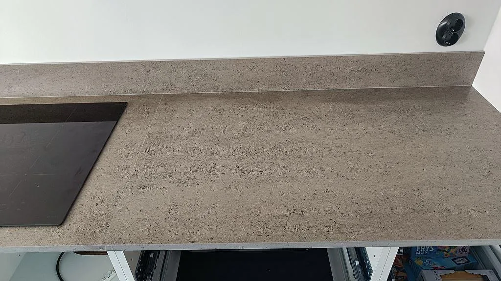 Arbetsyta i matt Dekton Keon keramik bredvid hällen och stänkkanten i ett kök i Veberöd.