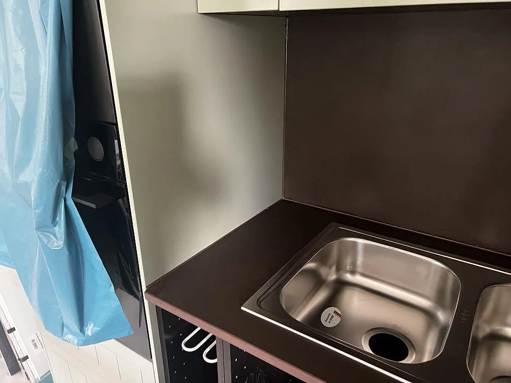 Detalj av mörk matt köksbänkskiva i Dekton Keranium med rostfri diskho och stänkskydd i Alingsås.
