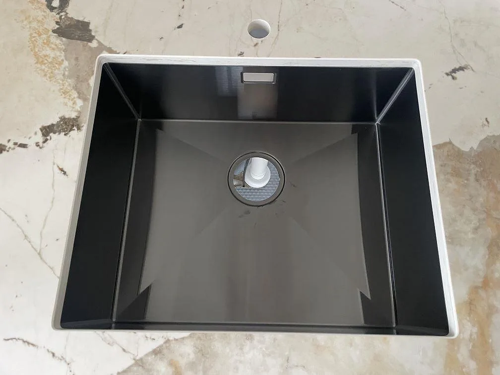 Svart underlimmad diskho monterad i polerad Dekton Khalo keramik med blandarhål i ett kök i København.